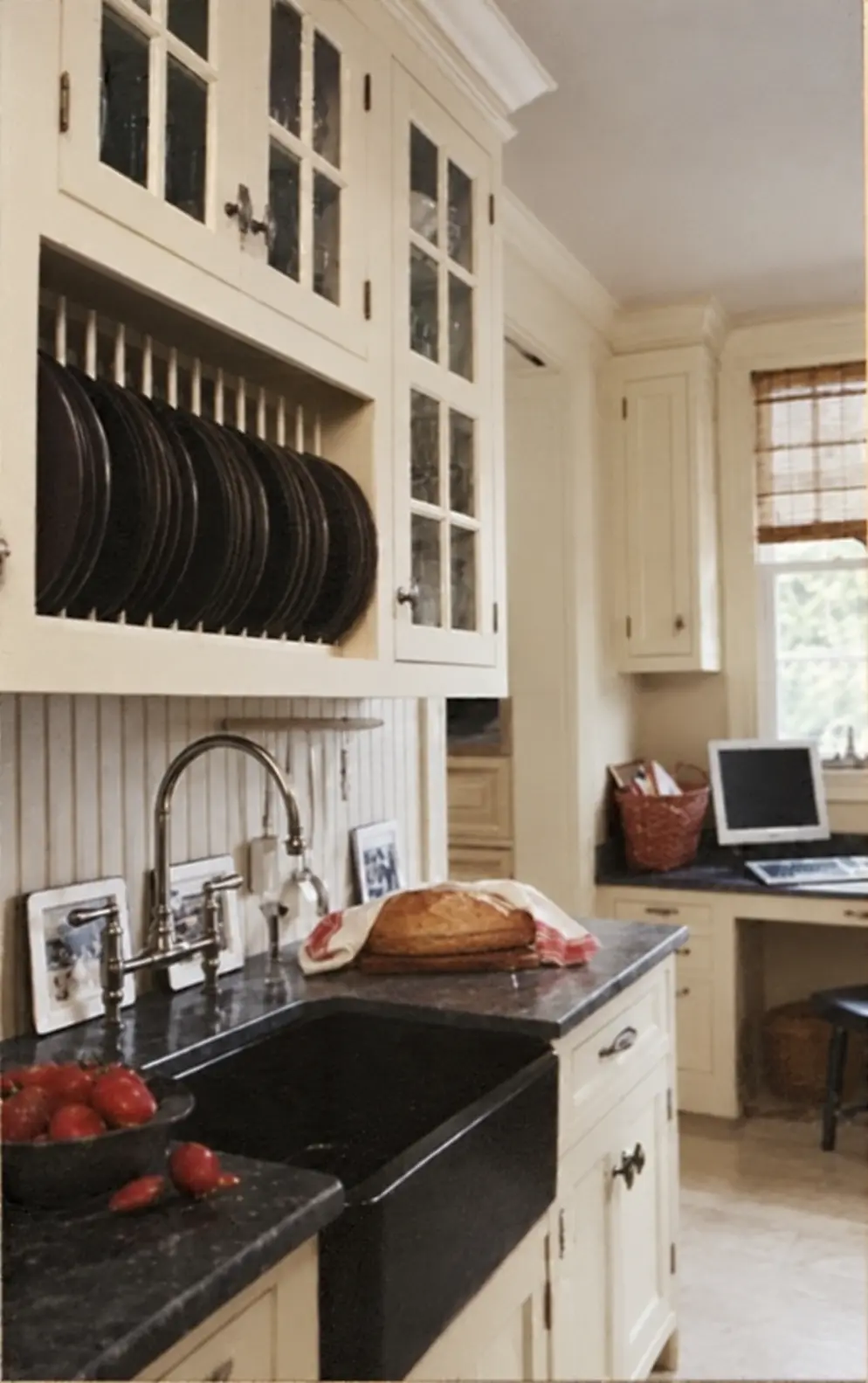 Restored archival photograph of the cook's pantry with a black farmhouse sink, cream plate rack and beadboard backsplash